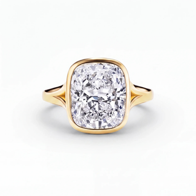The Celleste bezel set split shank engagement ring in 18ct yellow gold, a 5.00 carat cushion cut lab-grown diamond held in a full bezel