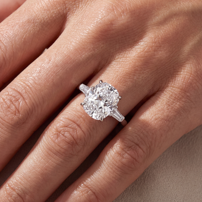 The Francis cushion cut lab grown diamond three stone engagement ring with tapered baguette side stones