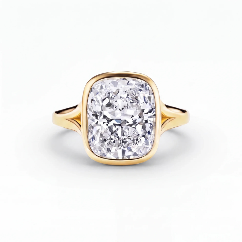 The Celleste bezel set split shank engagement ring in 18ct yellow gold, a 5.00 carat cushion cut lab-grown diamond held in a full bezel